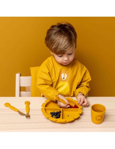 babero-con-mangas-leon-amarillo-trixie-4.jpg – Detalle del bolsillo recoge-migas.